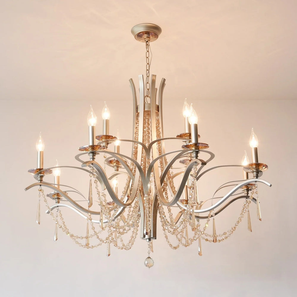 Close-up of the brushed gold metalwork and clear teardrop crystals on the tiered chandelier.