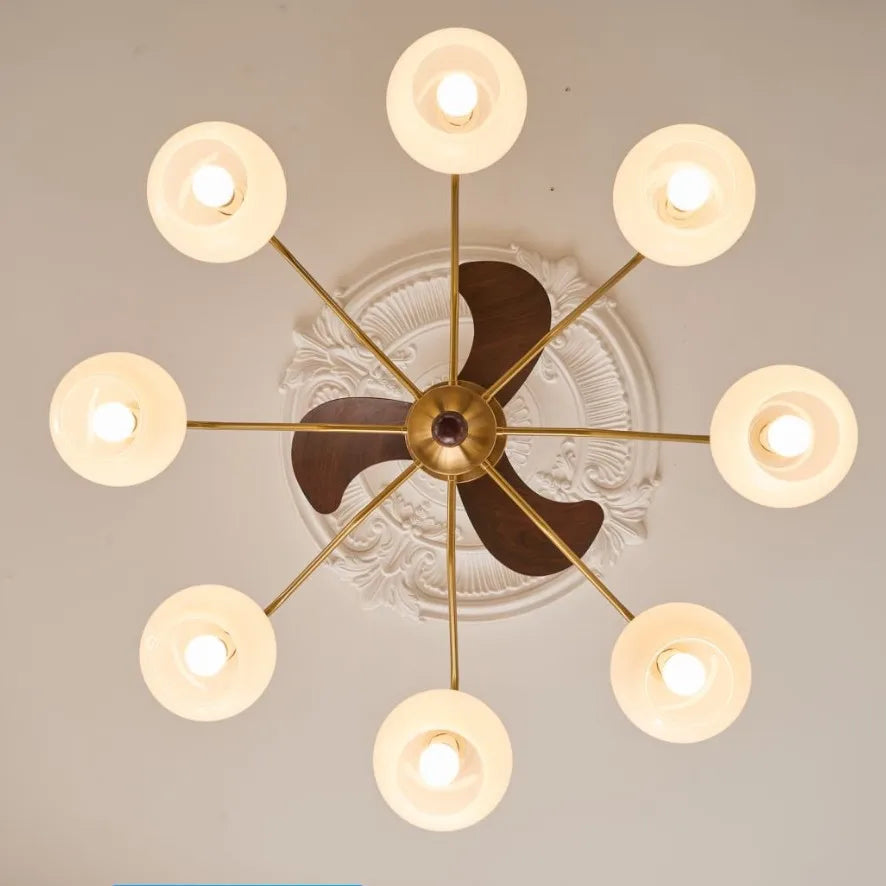 Modern chandelier with gold frame and glass shades on a ceiling.