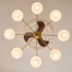 Modern chandelier with gold frame and glass shades on a ceiling.