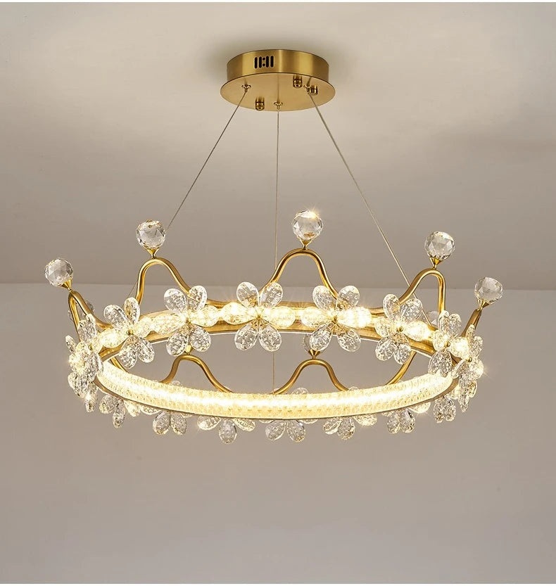 Gold chandelier with crystal accents on a plain background
