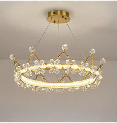 Gold chandelier with crystal accents on a plain background