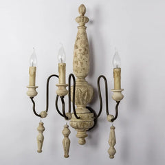 Decorative wall sconce with three candle-style lights on a plain background
