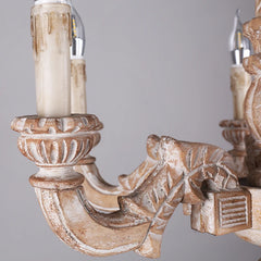 Close-up detail of one of the distressed wood arms and candle-style light holder of the chandelier.