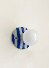 Close-up of the ceramic wall sconce base with blue and white stripes.