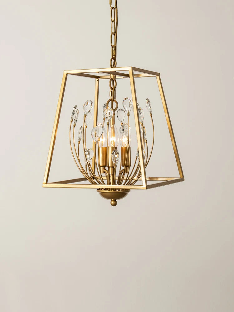 A studio shot of a gold metal cage pendant light with clear teardrop-shaped crystals against a plain white background.