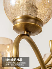 Detailed view of the brass material and construction of a gold chandelier arm and socket.