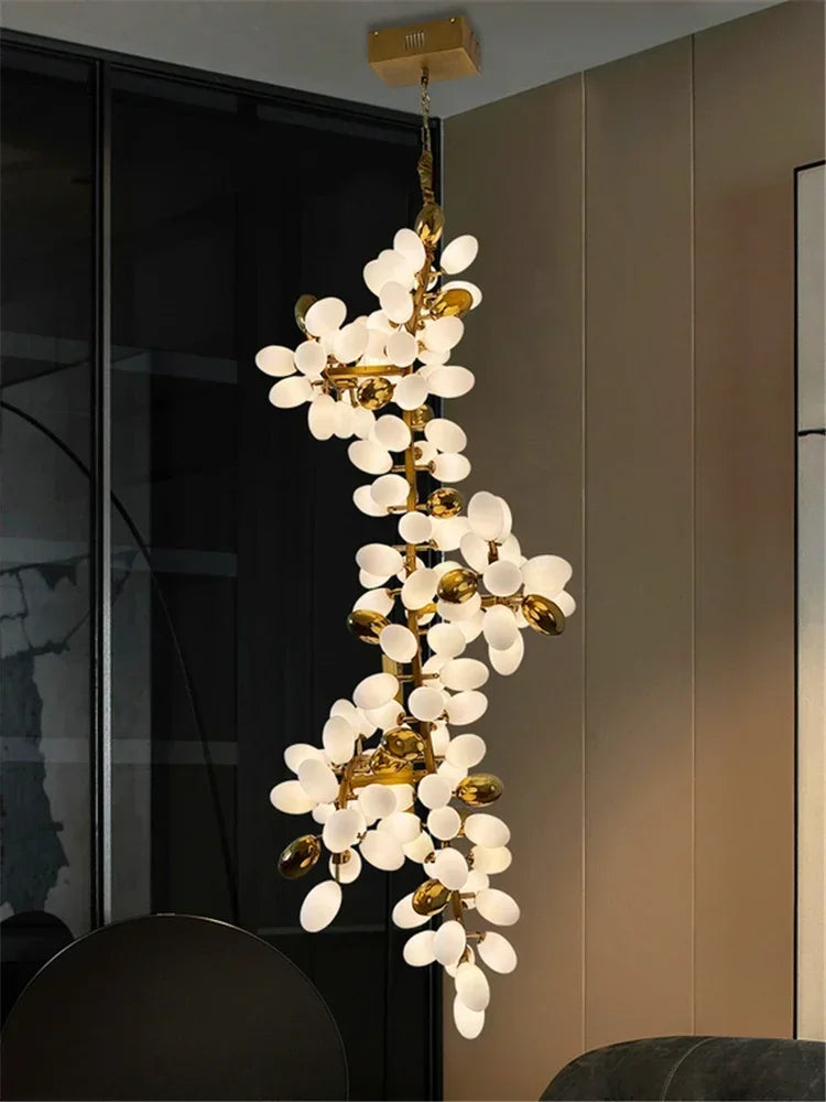 Modern chandelier with white glass and gold accents hanging in a room.