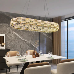 Modern chandelier hanging above a dining table in a stylish room with marble walls and large windows.