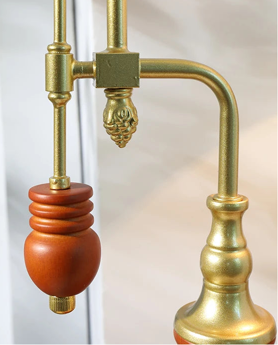 Brass and wooden lamp fixture with decorative elements on a white background