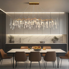 Modern kitchen with a chandelier, dining table, and chairs.