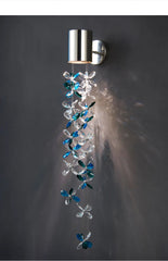 Polished chrome wall sconce featuring a hanging chain of blue and clear crystal flowers, creating a cascading effect with light.