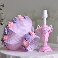 Decorative pink lamp with floral accents on a table