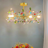 A gold-finished chandelier adorned with colorful crystal flowers and illuminated with integrated LED lights.