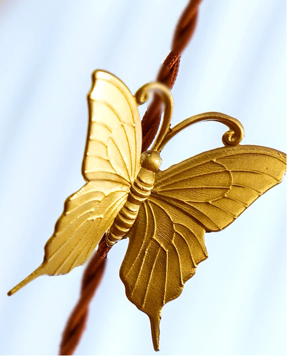 Gold butterfly decorative item on a blurred background