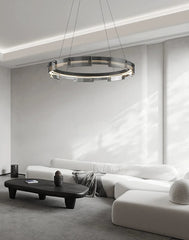 Modern living room with a chandelier, white sofa, and black coffee table.