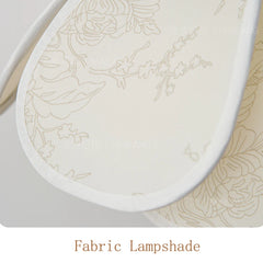 Fabric lampshade with floral pattern on a matching fabric surface