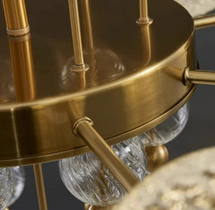 Close-up of a gold chandelier with glass shades on a dark background