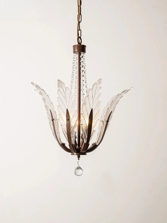 A close-up view of a bronze chandelier with clear glass leaf-shaped shades and a single hanging crystal.