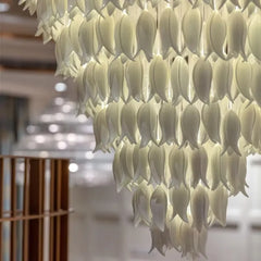 Decorative chandelier with leaf-like design in a blurred indoor setting