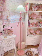 Pink floor lamp in a room with decorative items and wallpaper