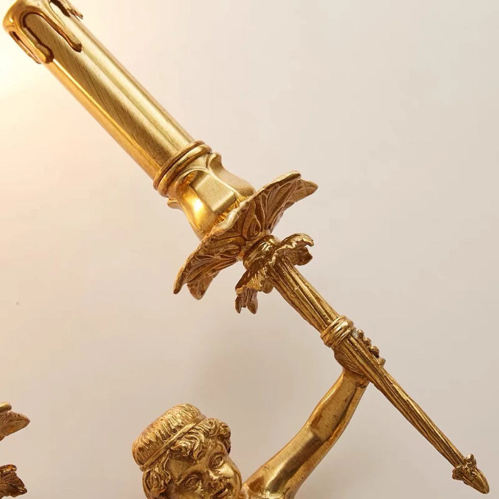 Gold-colored statue or sculpture with a detailed design on a beige background