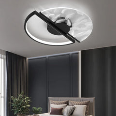 Black and white circular ceiling light with feather pattern glass shade and black frame, in a bedroom setting.