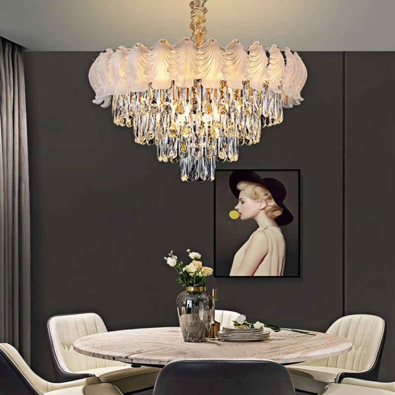 A glamorous tiered chandelier with cascading crystals and a polished chrome finish hangs above a dining table.