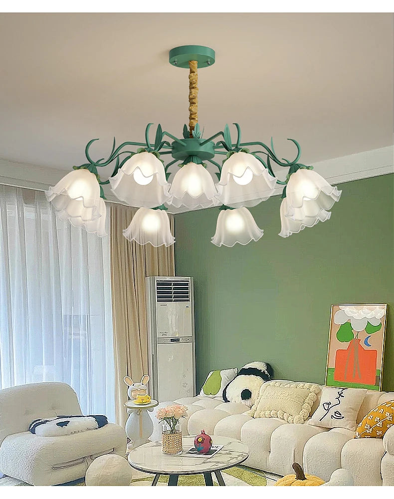Green floral pendant light illuminating a stylish living room with green walls and neutral furniture.