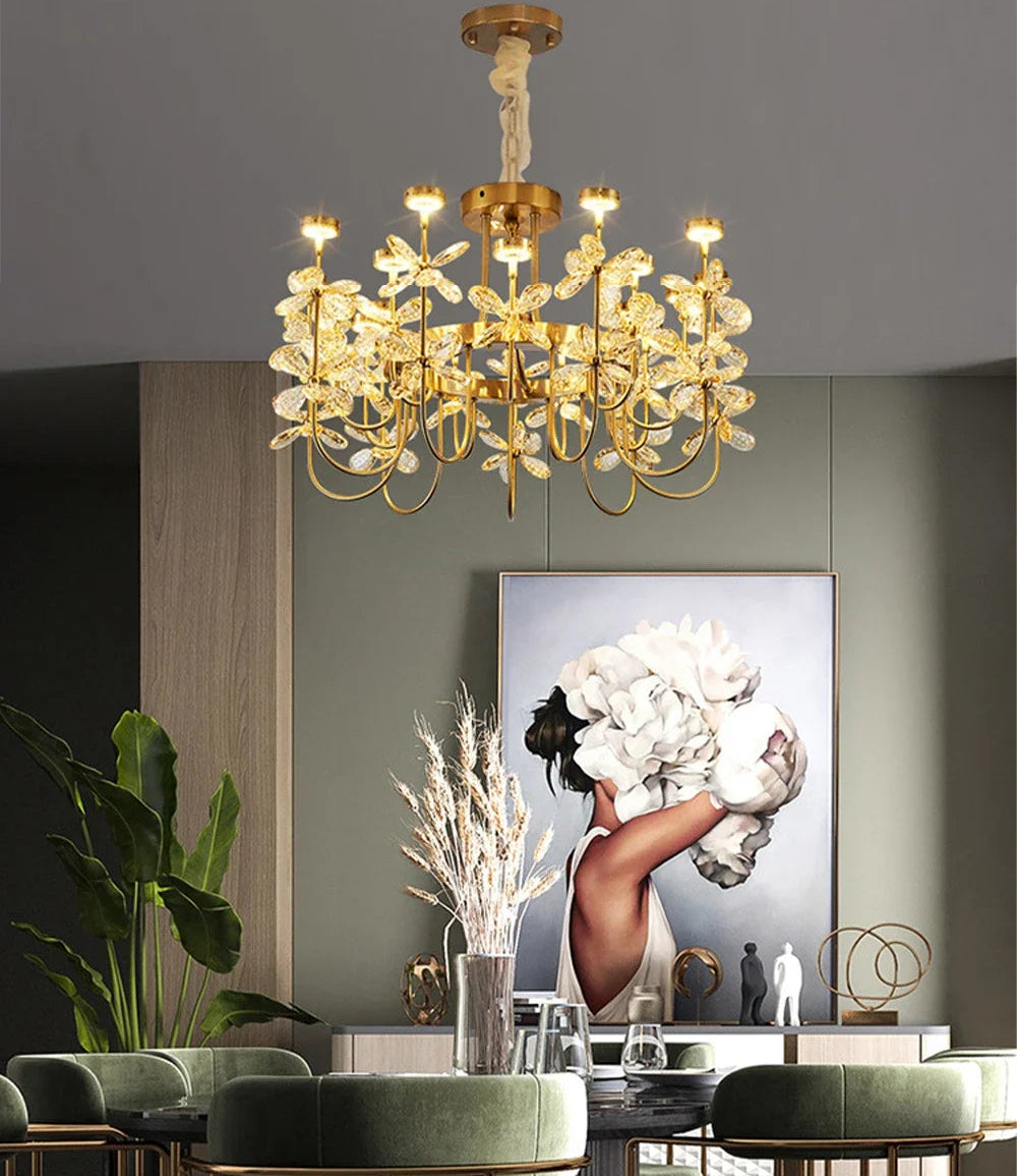 Gold chandelier hanging above a dining table with a modern painting on the wall.