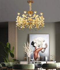 Gold chandelier hanging above a dining table with a modern painting on the wall.