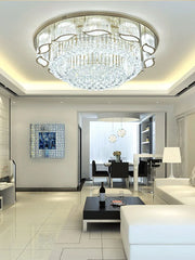 Modern living room with a chandelier, white sofa, and glass coffee table.