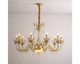 A gold candelabra chandelier with multiple arms adorned with faceted crystals, hanging from a ceiling.