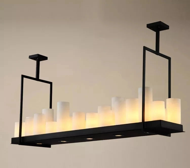 Modern black chandelier with white candles on a beige background