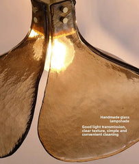 Gold glass lampshade with a light bulb inside on a white background