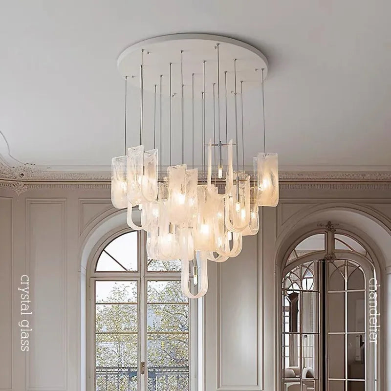 Chandelier with many clear glass tubes and visible LED bulbs hanging in a room