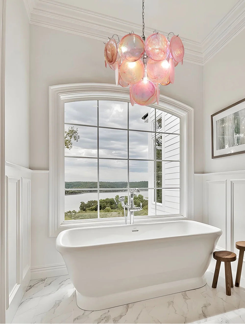 Bathroom with freestanding bathtub, pink chandelier, and large window view.