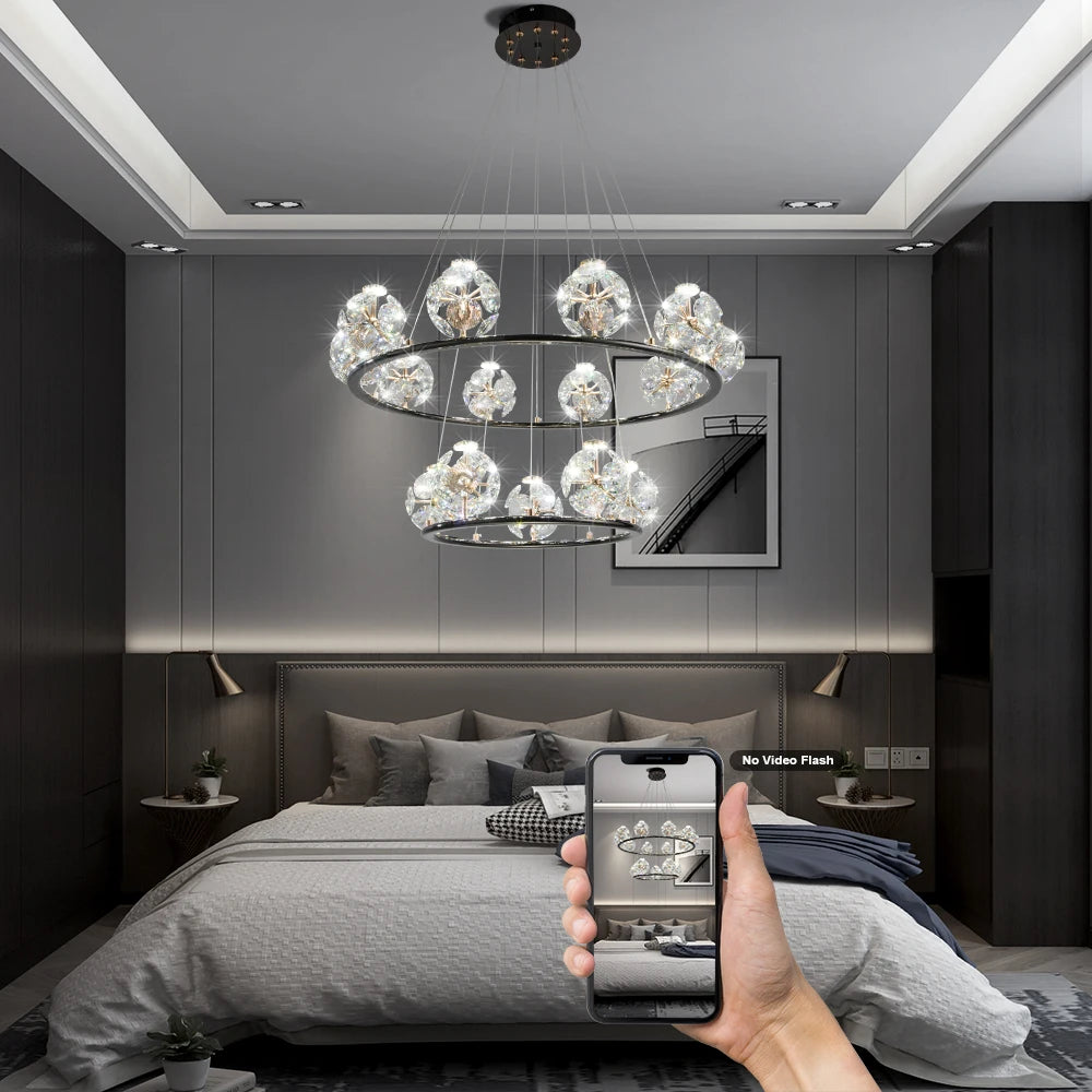 Two-tiered chandelier with crystal orb accents and gold frame in a bedroom setting.
