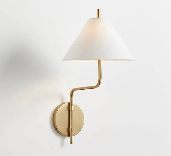 Wall-mounted lamp with a white shade and gold arm on a light gray background