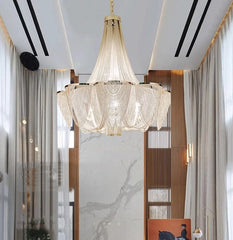 Luxurious chandelier hanging in a modern interior setting with marble walls and wooden panels.