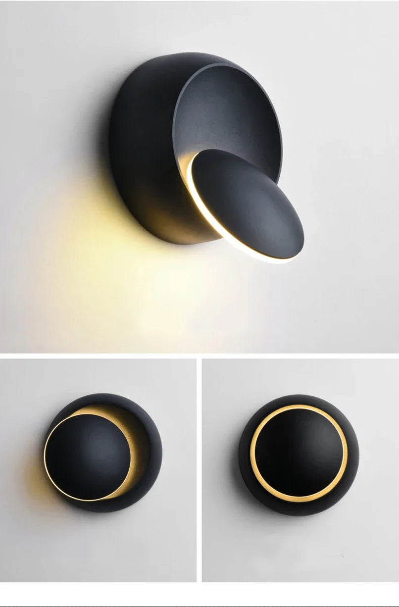 Modern black wall light fixture with a warm glow on a white background