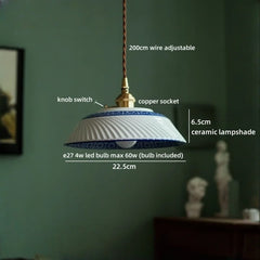 Pendant light with labeled features against a green wall
