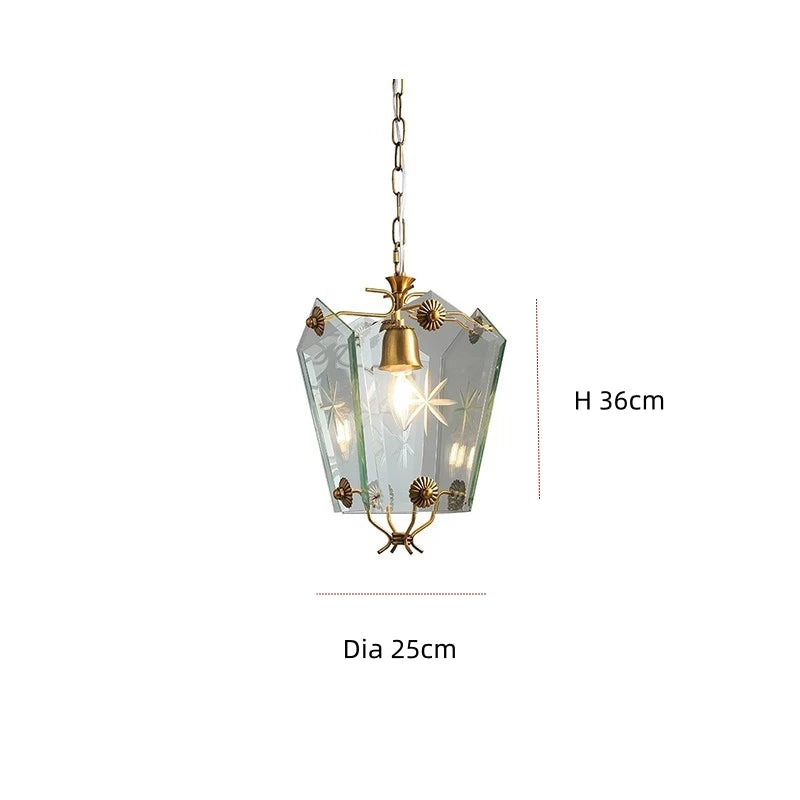 Pendant light with gold accents and clear glass shade on a white background