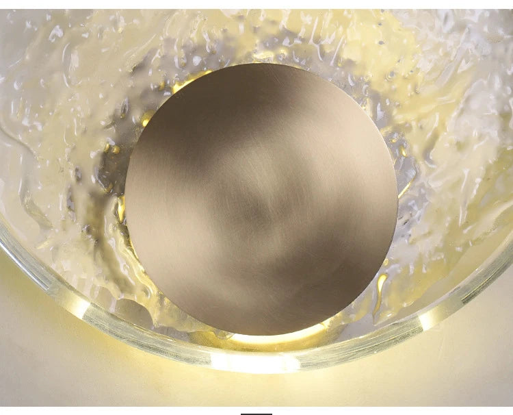 Decorative wall light fixture with gold sphere and glass casing