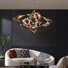 Close-up of a rose gold geometric crystal pendant light with intricate facets, hanging against a dark wall.