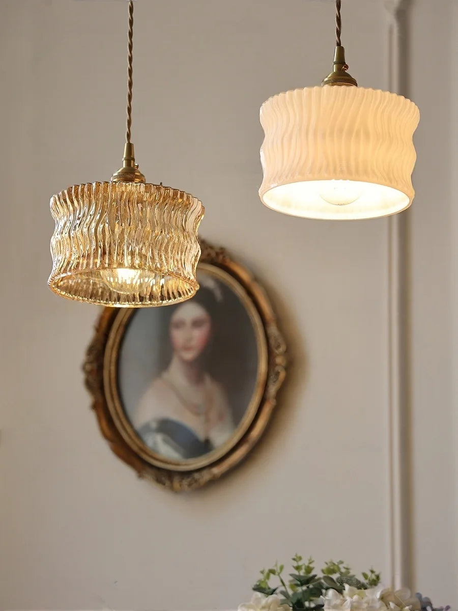 Two pendant lights hanging above a portrait on a wall.