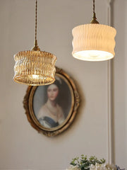 Two pendant lights hanging above a portrait on a wall.