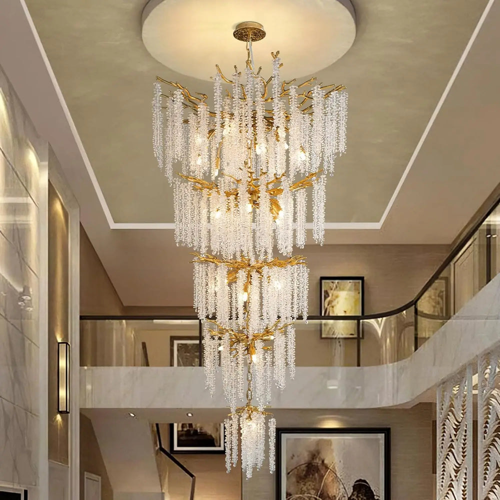 Luxurious chandelier hanging in a stylish interior setting with staircase and wall art.