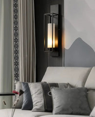 Modern wall sconce above a sofa with decorative pillows