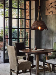 Dining area with wooden table and chairs, rustic pendant light, and large window.