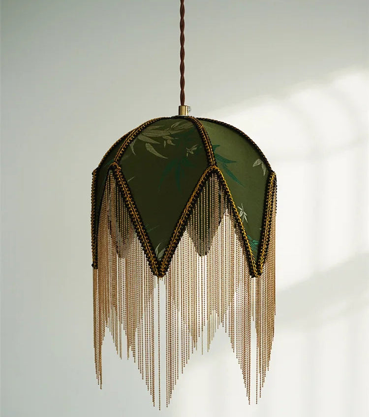 Decorative pendant light with green lampshade and gold fringes on a white background